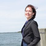 Headshot of Vivero Fellow Livia Stein Freitas on a dock in front of the ocean